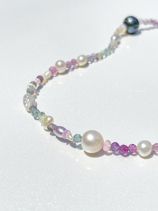 Nāmaka Fluorite with Akoya &amp; Tahitian Pearl Fine Choker Necklace  This necklace is bound to catch the eye! Each Fluorite gem is multi-faceted, sparkling and shining in every light. With unique colours and patterns, sparkle and shine in soft pastel shades.  Highlighted by Estate Re-purposed Tahitian Black Pearls &amp; Akoya Pearls, asymmetrically placed around the neckline. A scattering of freshwater pearls and Ethiopian Opals highlight the piece. Finished with solid Sterling Silver hardwear.   This neck